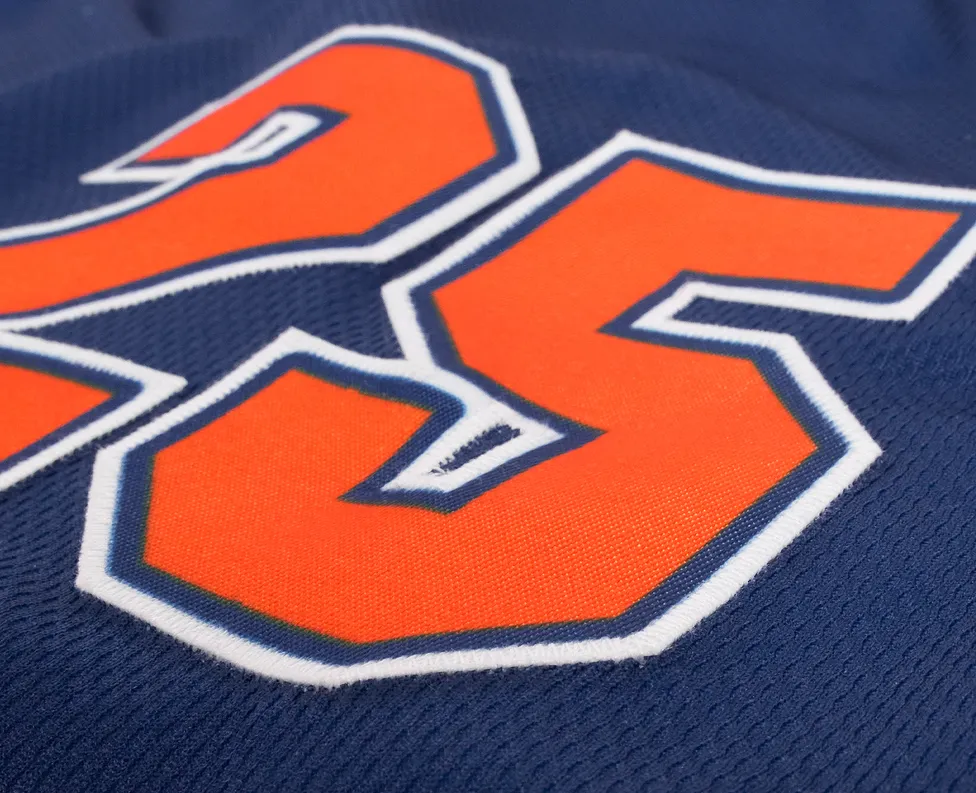 Close-up of a blue sports jersey featuring the number 25 in bright orange.