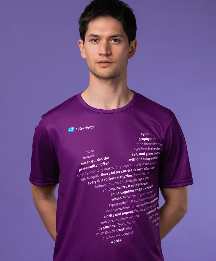 A man is wearing a purple sports shirt featuring typographic text on the front, set against a purple background.