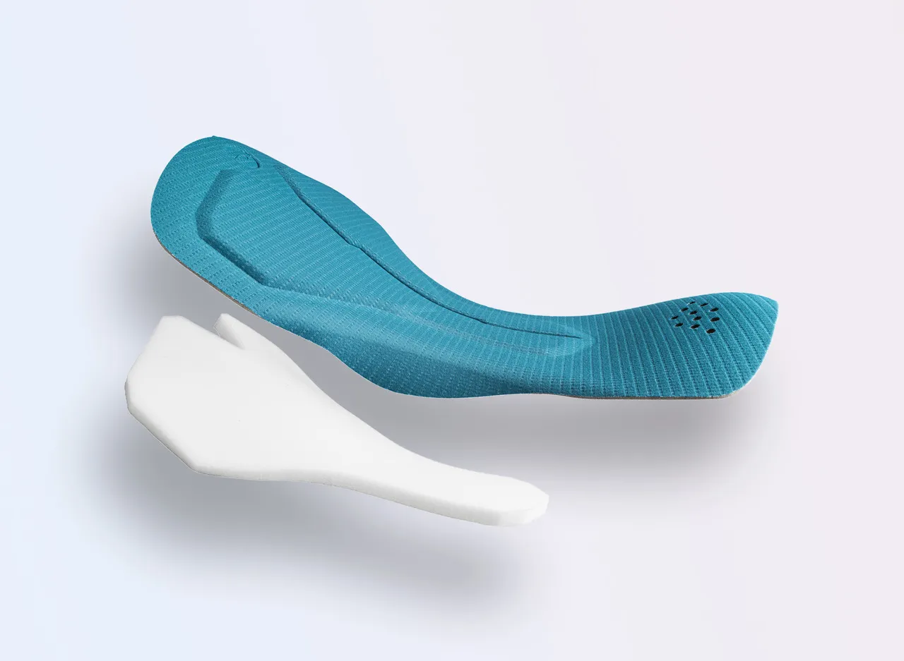 Two sports insoles in different colors, one blue and one white, resting on a light background.